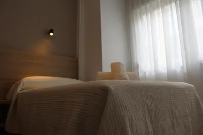 a bedroom with a white bed and a window at Apartamentos Rego Foz in Foz