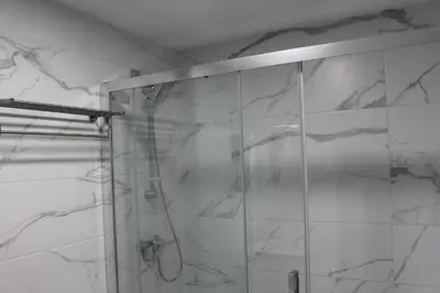 a shower with a glass door in a bathroom at Apartamentos Rego Foz in Foz