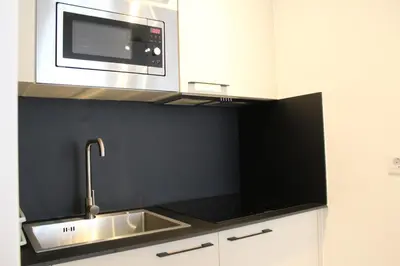 a kitchen with a sink and a microwave at Apartamentos Rego Foz in Foz
