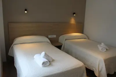 two beds in a hotel room with towels on them at Apartamentos Rego Foz in Foz