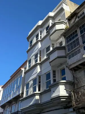 a white building with windows and a blue sky at La Fantástica Pontedeume 2 in Puentedeume