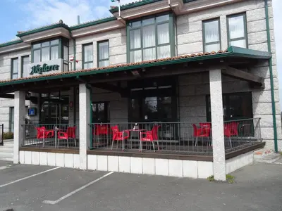 a restaurant with red tables and chairs on a balcony at Hotel Akelarre in Santiago de Compostela