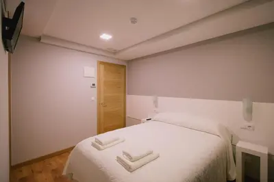 a bedroom with a bed with two white towels on it at Hospederia Tarela in Santiago de Compostela