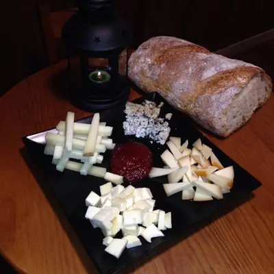 a plate of food with cheese and bread on a table at Hospederia Tarela in Santiago de Compostela