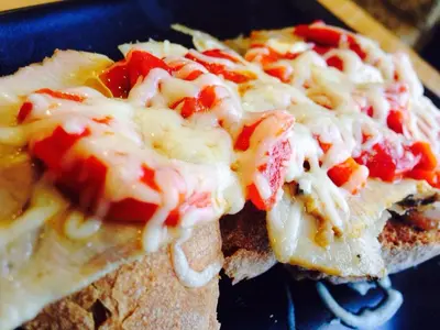 two slices of bread with cheese and tomatoes on it at Hospederia Tarela in Santiago de Compostela