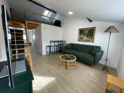 a living room with a green couch and a table at Céntrico estudio muralla romana in Lugo