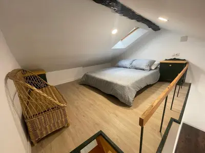a attic bedroom with a bed and a staircase at Céntrico estudio muralla romana in Lugo