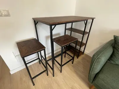 a table and two stools next to a couch at Céntrico estudio muralla romana in Lugo