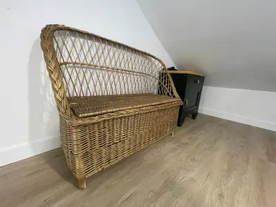 a wicker chair sitting in a corner of a room at Céntrico estudio muralla romana in Lugo