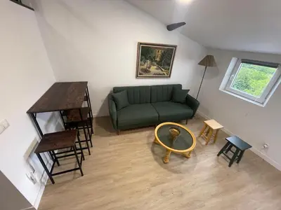 a living room with a green couch and a table at Céntrico estudio muralla romana in Lugo