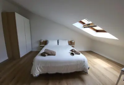 a bedroom with a white bed and a skylight at Apartamentos Lavandeira by beBalmy in Viveiro