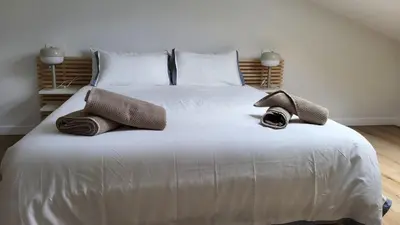 a large white bed with two towels and a hat on it at Apartamentos Lavandeira by beBalmy in Viveiro