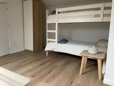 a bedroom with a bunk bed and a table at Apartamentos Lavandeira by beBalmy in Viveiro