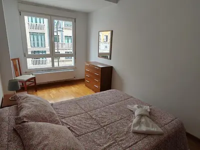 a bedroom with a bed and a dresser and a window at Os Garitos in Ribadeo