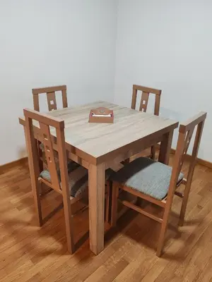 a wooden table with two chairs and a purse on it at Os Garitos in Ribadeo