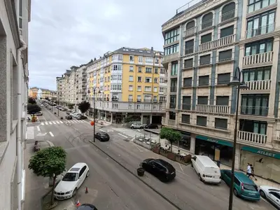 a city street with cars parked in front of buildings at Os Garitos in Ribadeo