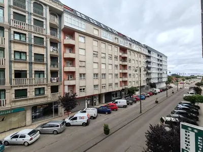 a street with cars parked in front of a building at Os Garitos in Ribadeo