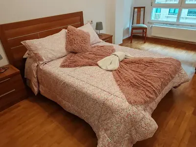 a bedroom with a bed with a purse on it at Os Garitos in Ribadeo