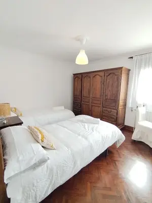 a bedroom with a white bed with a wooden cabinet at Covas Beach Ocean in Covas