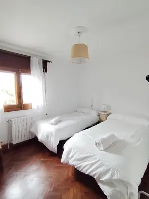 two beds in a white room with a window at Covas Beach Ocean in Covas