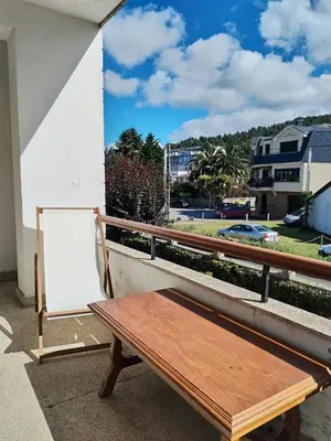 a wooden bench sitting on top of a balcony at Covas Beach Ocean in Covas