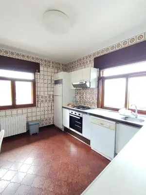 a kitchen with white appliances and two windows at Covas Beach Ocean in Covas