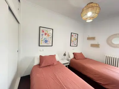 a bedroom with two beds and a lamp at A Finca Da Toñita in Ribadavia