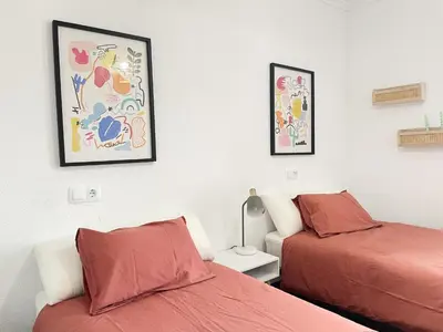 a bedroom with two beds and a lamp and pictures on the wall at A Finca Da Toñita in Ribadavia