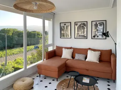 a living room with a couch and a large window at A Finca Da Toñita in Ribadavia