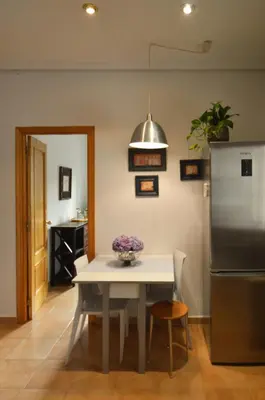 a kitchen with a white table and a refrigerator at Apartamento entero céntrico en Ourense in Ourense