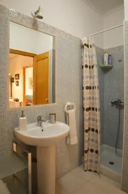 a bathroom with a sink and a shower with a mirror at Apartamento entero céntrico en Ourense in Ourense