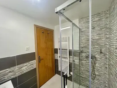a bathroom with a shower and a glass door at Piso Turístico Felipe Herce in Ponferrada