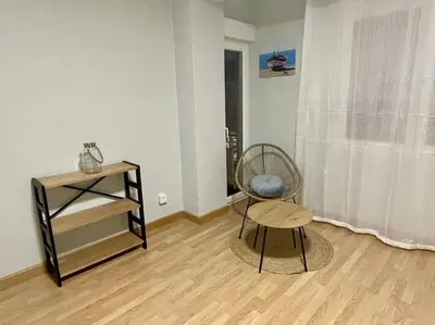 a living room with a chair and a stool at Piso Turístico Felipe Herce in Ponferrada
