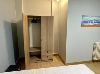 a wooden cabinet in a room with a bed at Piso Turístico Felipe Herce in Ponferrada