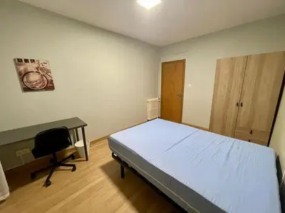 a bedroom with a bed and a desk in it at Piso Turístico Felipe Herce in Ponferrada