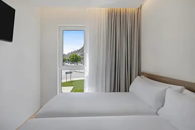 a bedroom with a bed and a window at B&B HOTEL Santiago Milladoiro in Milladoiro