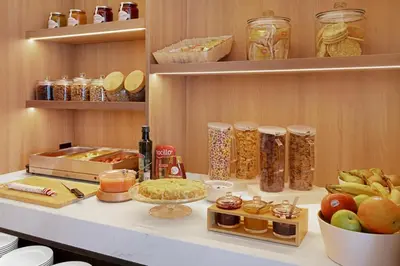 a kitchen with a counter with food on it at B&B HOTEL Santiago Milladoiro in Milladoiro