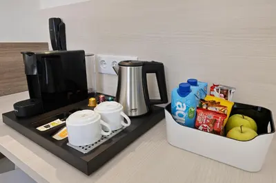 a counter with a coffee maker and a box of food at B&B HOTEL Santiago Milladoiro in Milladoiro