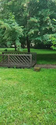 a wooden fence in a field with a tree at As Erdades in Ourense