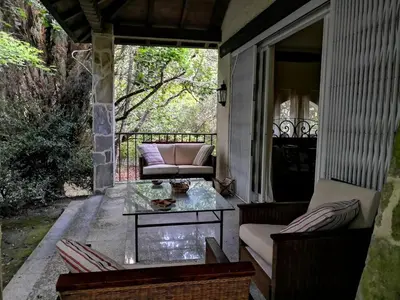 a patio with a couch and a table on a porch at As Erdades in Ourense