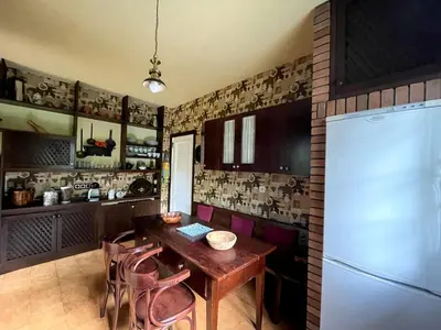a kitchen with a wooden table and a refrigerator at As Erdades in Ourense