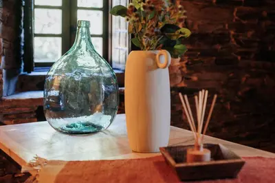 a table with a glass vase and a white vase at Casa do Corral in Hospital