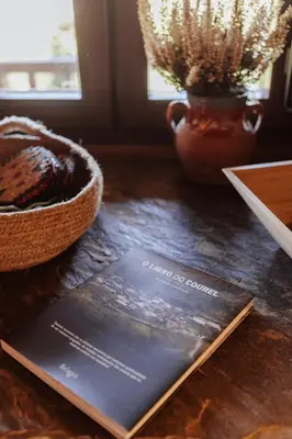 a book sitting on a table next to a vase at Casa do Corral in Hospital