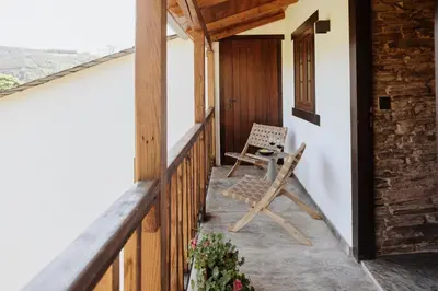 a porch with a chair and a door at Casa do Corral in Hospital