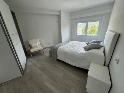 a bedroom with a bed and a chair and a window at Oktheway Caldas Centro in Caldas de Reis