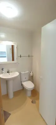 a bathroom with a toilet and a sink and a mirror at EnBURELA Confort y Relax in Burela de Cabo