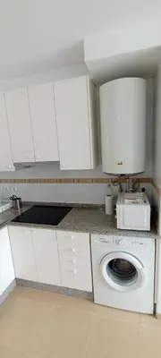 a white kitchen with a washing machine in it at EnBURELA Confort y Relax in Burela de Cabo