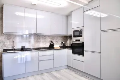 a white kitchen with white cabinets and appliances at Rosalia Park by Lugo Collection in Lugo