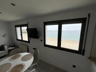 a dining room with a table and a view of the beach at Apartamento BURELA PALOMA PLAYA in Burela de Cabo
