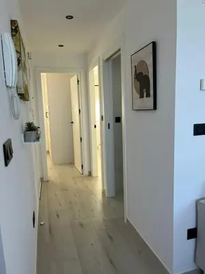 a hallway with white walls and a hard wood floor at Apartamento BURELA PALOMA PLAYA in Burela de Cabo